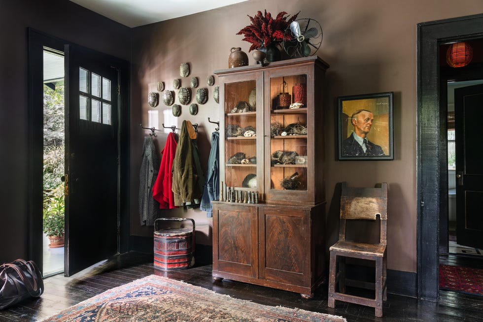 cozy 1940 craftsman cottage owned by leighton, alabama, landscape gardener anthony brewington entry with cabinet, brown walls dark chocolate benjamin moore