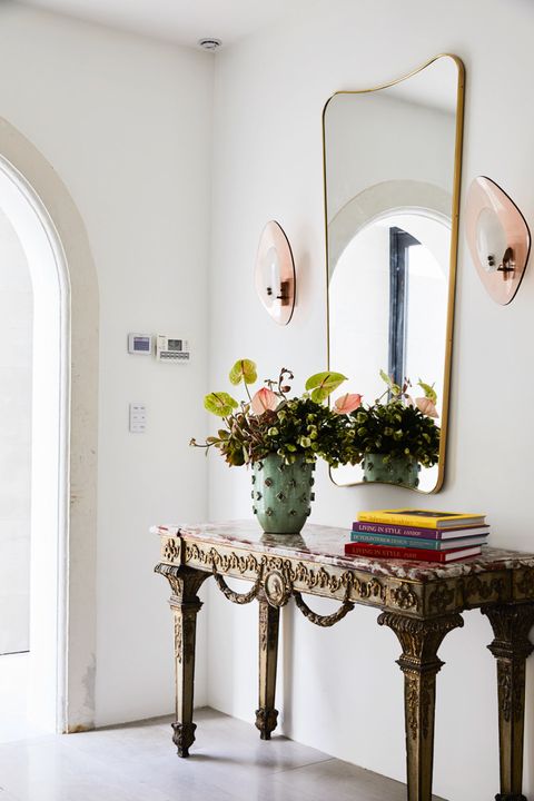entryway with formal consol and modern mirror and sconces