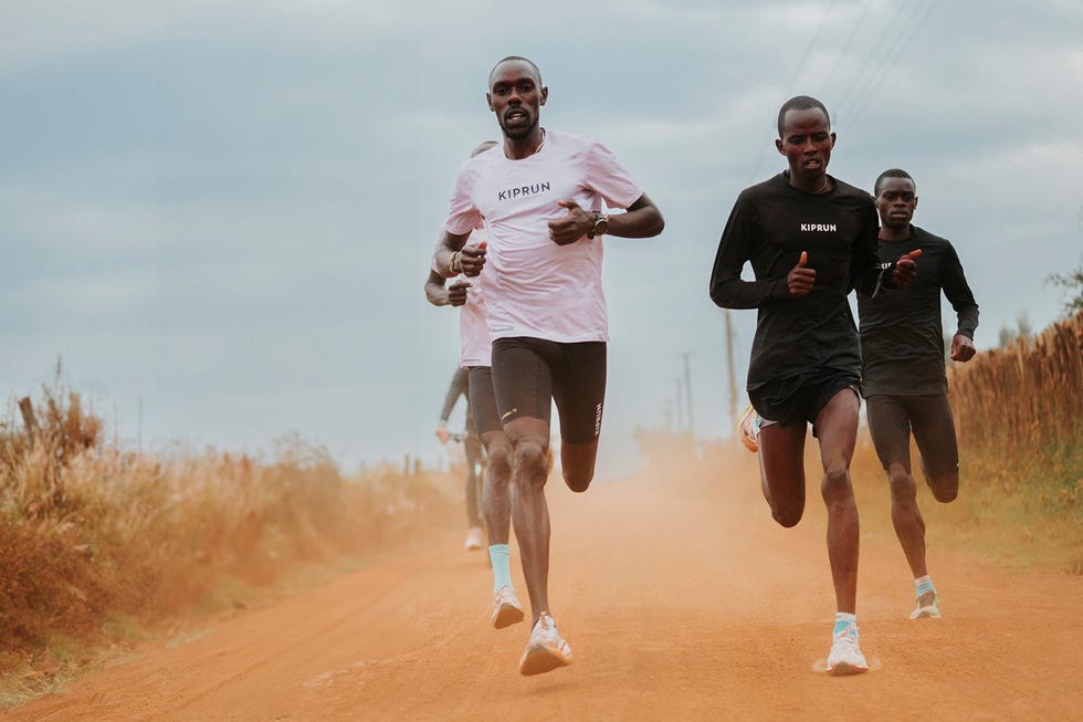 a group of men running on a dirt road