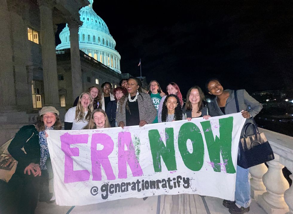 congresswoman cori bush standing with organizers on the steps of the capitol holding a banner that says era now