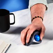 ergonomic mouse on desk with mug and laptop