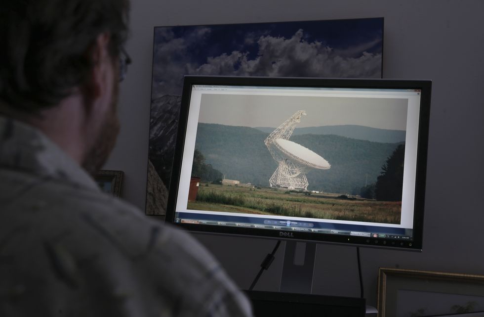 director of seti shows the green bank radio telescope on his computer screen