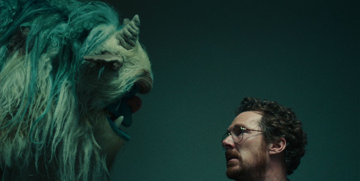 benedict cumberbatch looks eye to eye with a large monster puppet