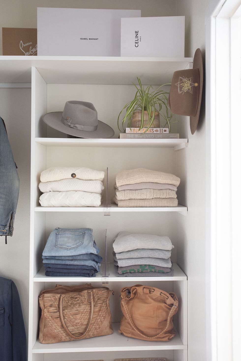a white closet with a variety of hats and a plant