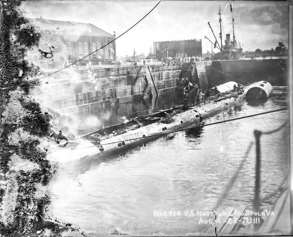 Deze foto werd op 16 augustus 1922 gemaakt en is waarschijnlijk een van de allerlaatste die van de U111 bekend zijn Te zien is hoe een team op de marinewerf in Norfolk Virginia de Uboot voorbereid op zijn laatste reis naar de plek in de Atlantische Oceaan waar hij met behulp van explosieven tot zinken zou worden gebracht