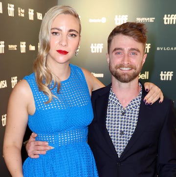 Erin Darke and Daniel Radcliffe erin darke in a blue dress and with daniel radcliffe who is wearing a black suit and checkered tie