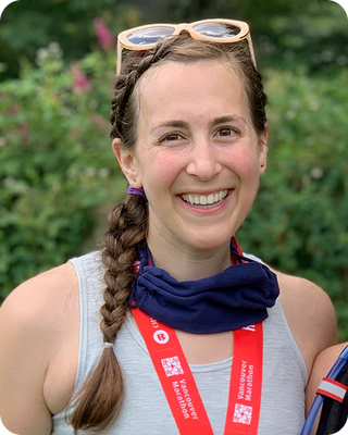 a woman smiling for the camera with a race medal around