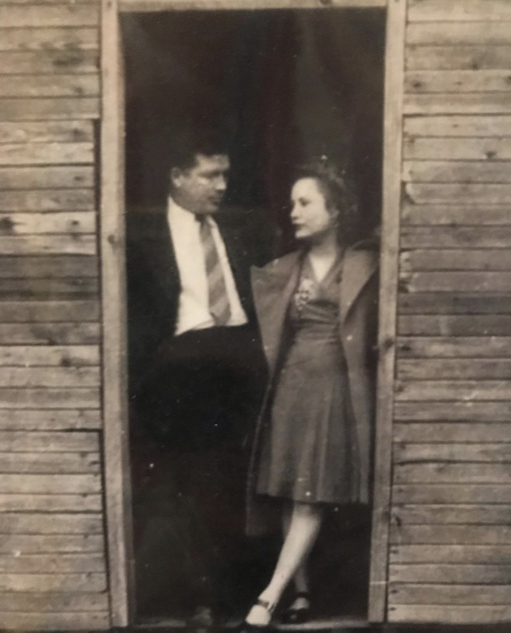 sepia toned photo of erin napier's grandparents standing in a wooden doorway