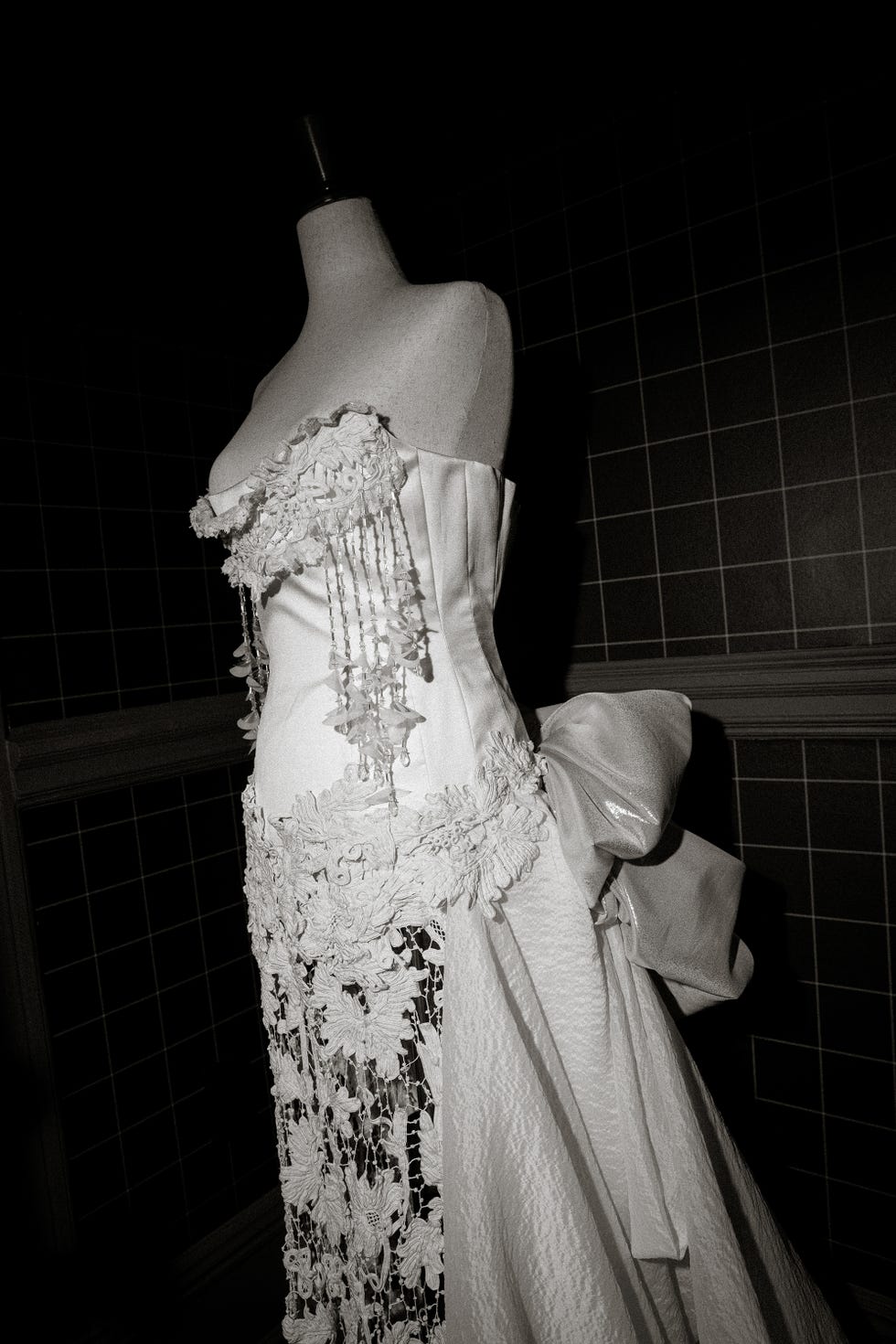 elegant white gown on a mannequin showcasing intricate detailing and design