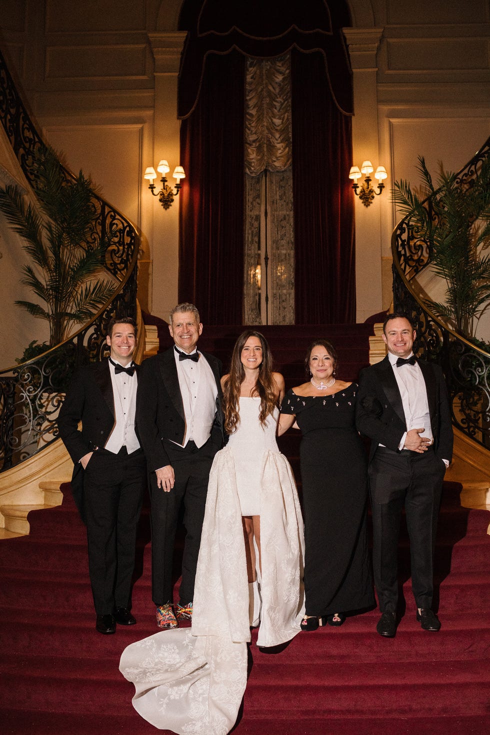 group of individuals dressed in formal attire standing on a staircase