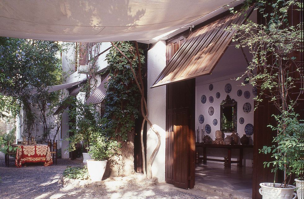 side view of the house with open doors and canopies for shade and with a table and chairs outside beneath it