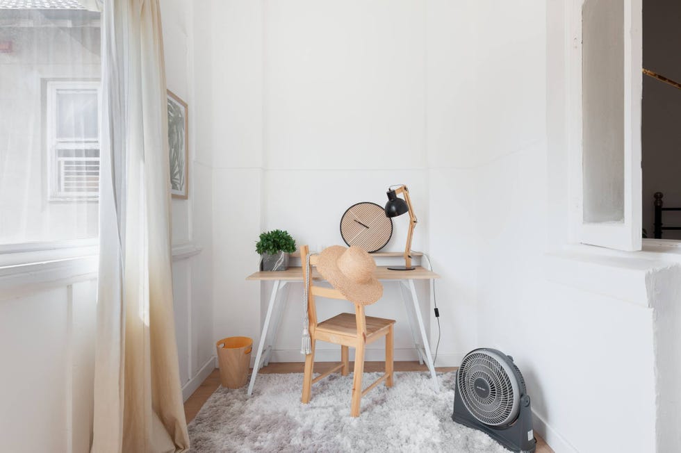 despacho de estilo minimalista en color blanco con silla de madera