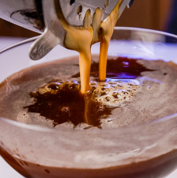 straining an espresso martini in a glass