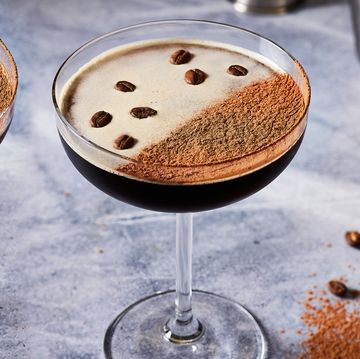 espresso martini in a coupe glass topped with espresso powder and coffee beans
