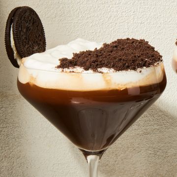 espresso mocha crunch mocktail in a martini glass with a whipped cream and chocolate topping and oreo garnish