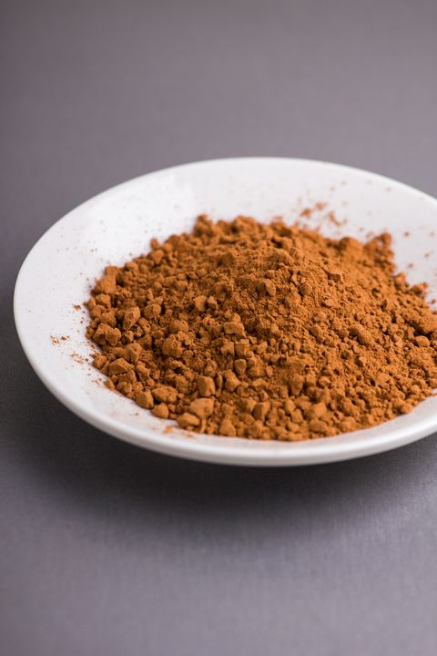 cocoa powder in plate on gray background