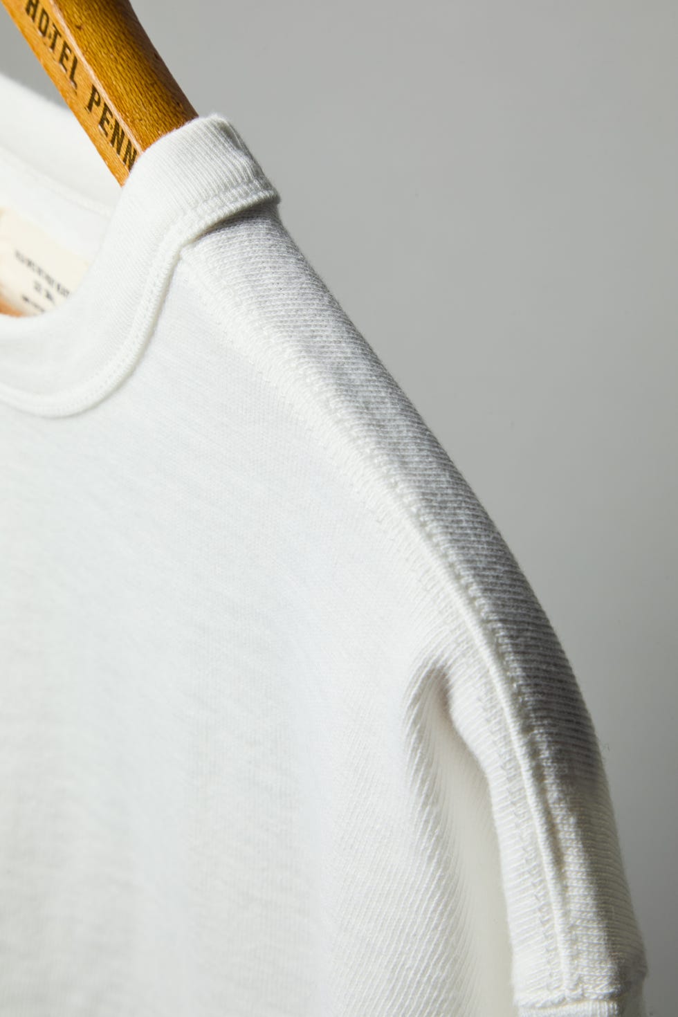 a white t shirt on a wooden hanger