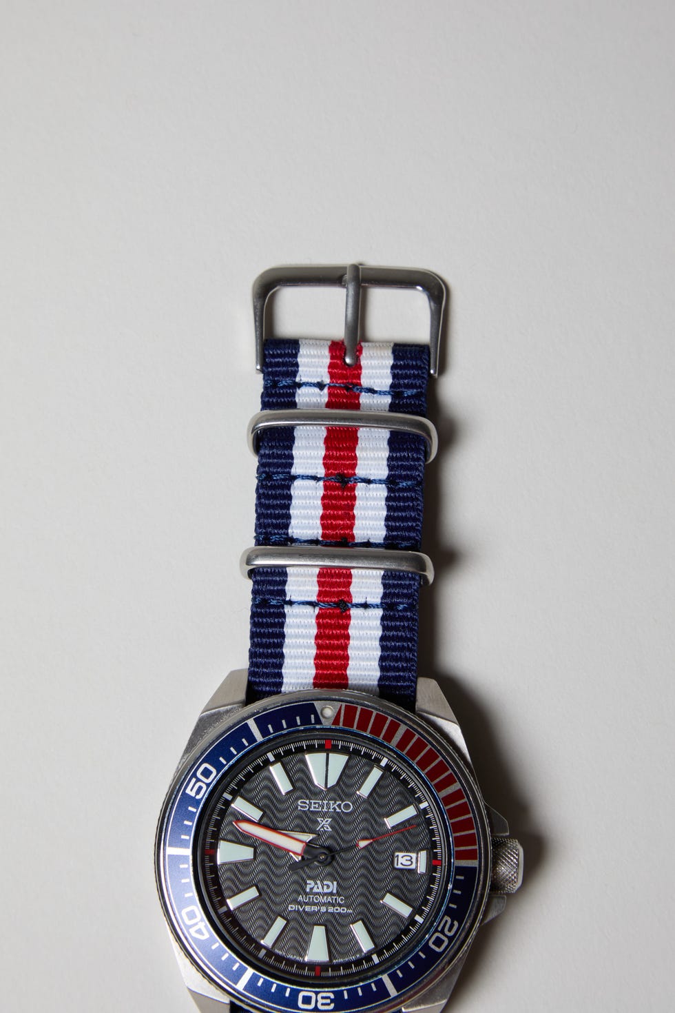 a red white and blue nato watch strap on a seiko watch