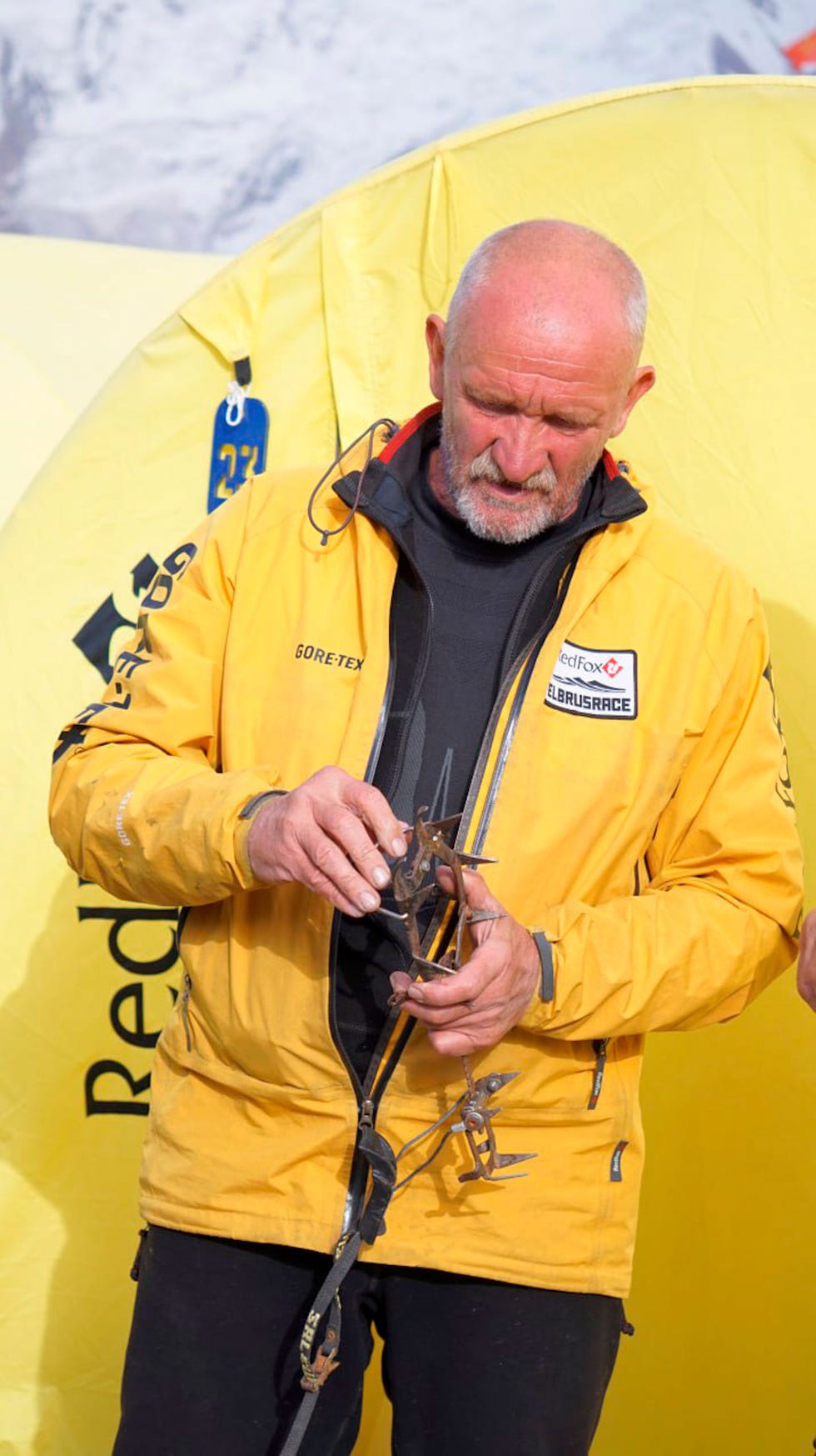 scalatore che mostra l'attrezzatura da arrampicata