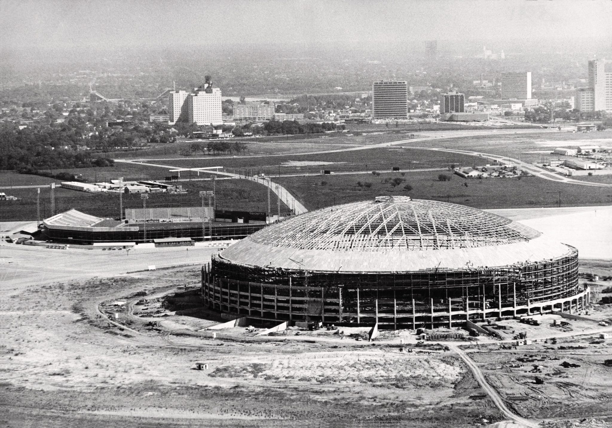O estádio do condado de Harris, com cúpula, foi mostrado em 1964, vários meses antes de sua inauguração. O antigo estádio Colt, que foi a casa do time de beisebol Houston Heat, Mosquitos e Colt .45s, fica no canto superior esquerdo. (Foto AP/Houston Chronicle, Sam C. Pierson)