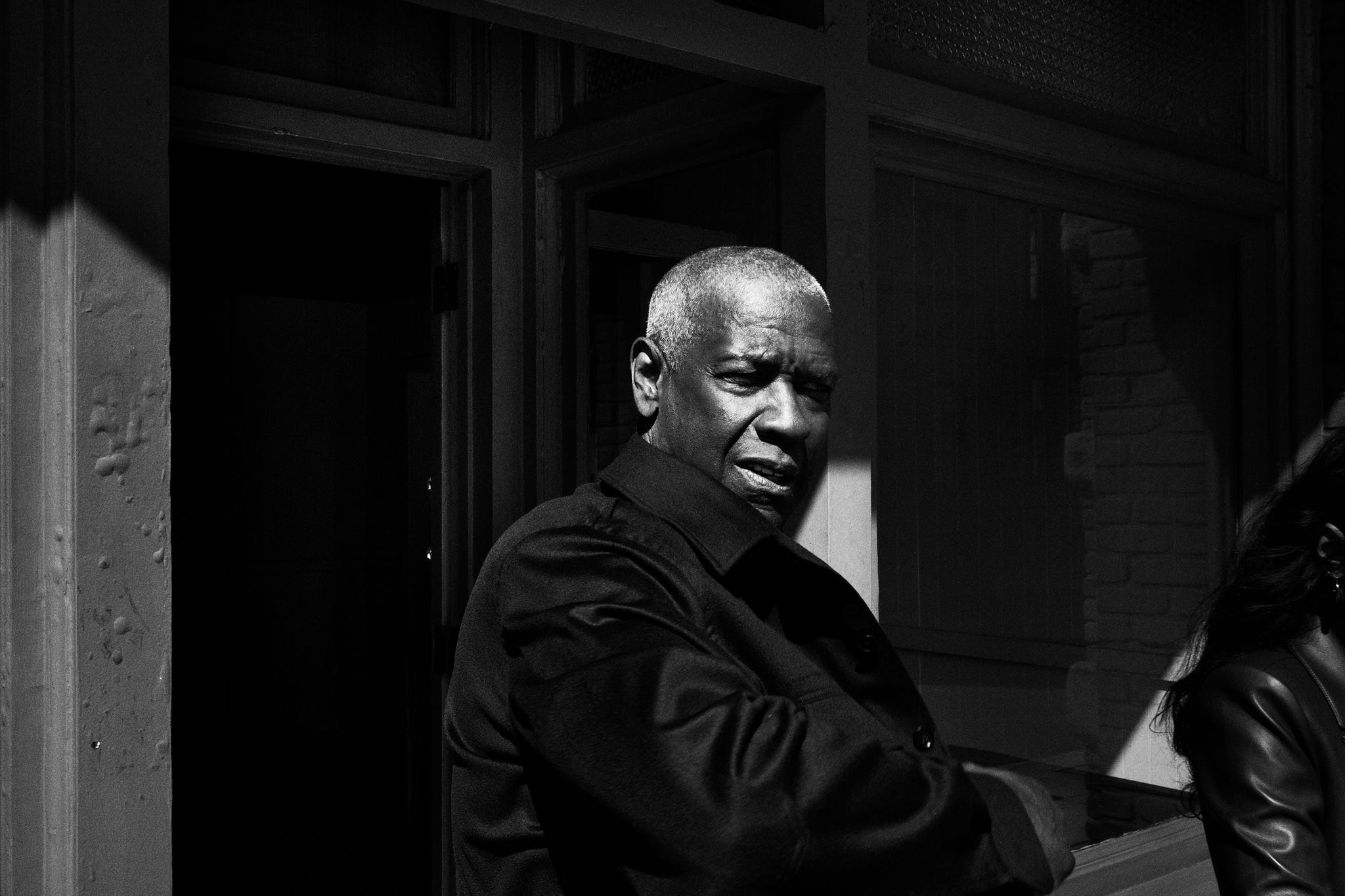 a person standing outside a building in a shadowy environment