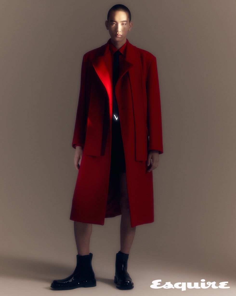 a mannequin wearing a red coat and black shoes