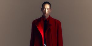 a mannequin wearing a red coat and black shoes from valentino
