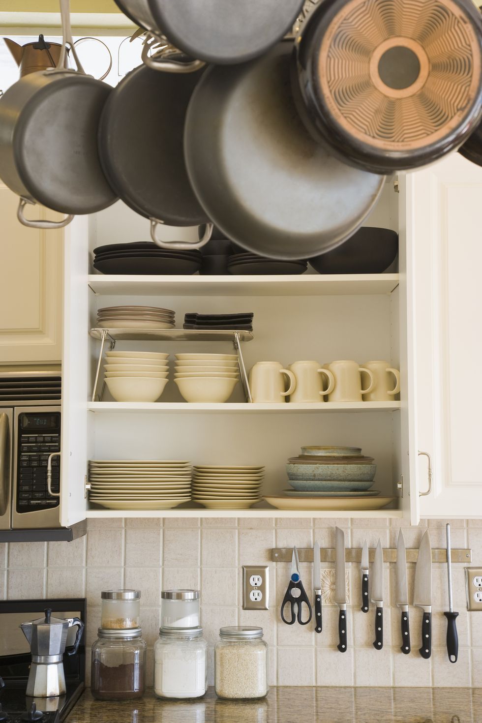 Estantes de madera de cocina con varios frascos de cerámica y utensilios de cocina  estantes abiertos en la cocina