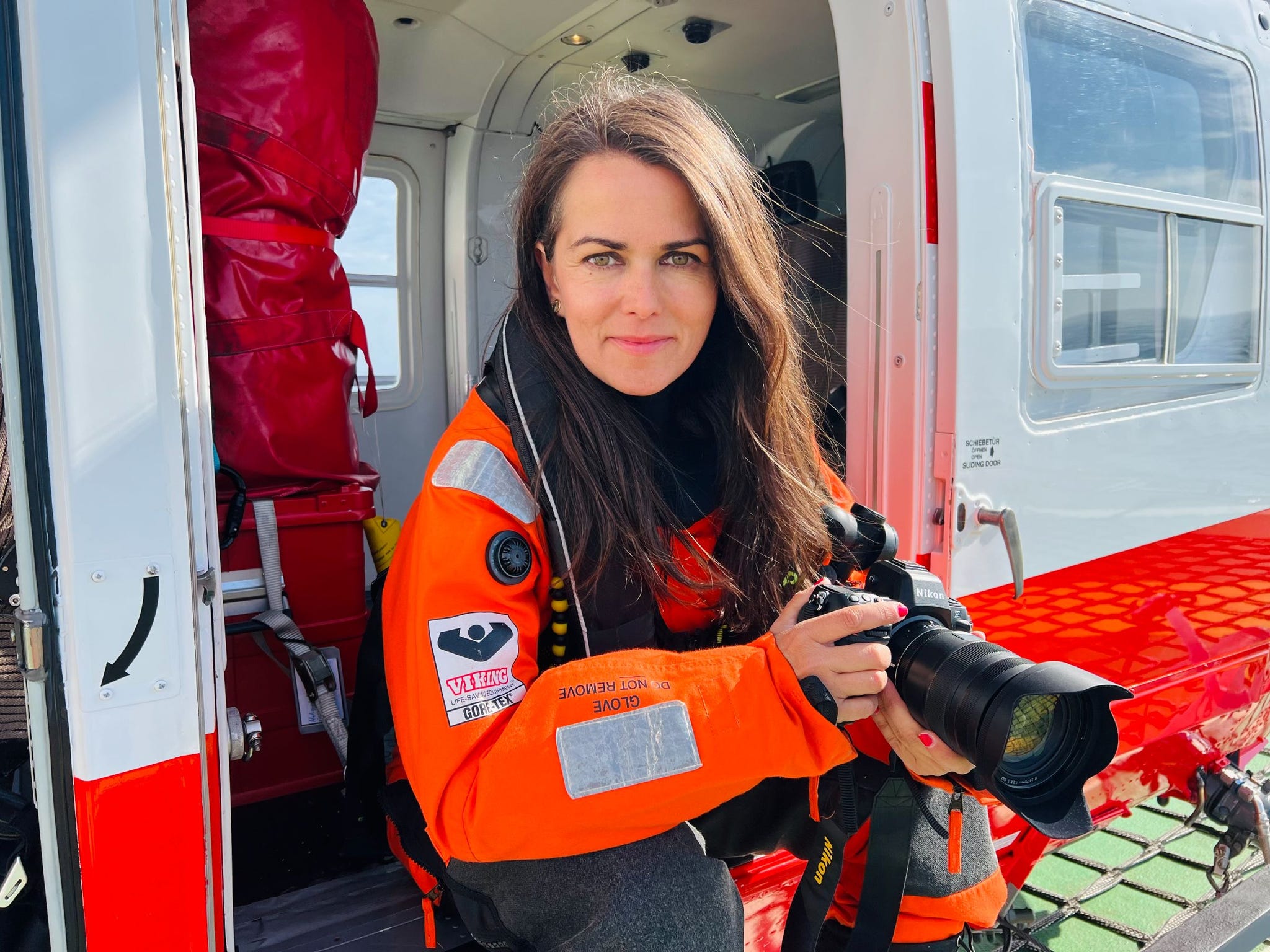 fotograaf esther horvath stapt uit een helicopter met een camera in haar hand