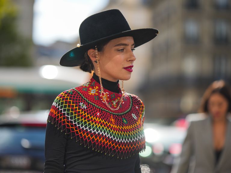 paris, france   september 30 a guest wears a black felt wool hat with a gold chain, a black and silver triangular earring from prada, a black turtleneck t shirt, a red  green  yellow  white mesh print pattern high neck breastplate, outside giambattista valli, during paris fashion week   womenswear springsummer 2023, on september 30, 2022 in paris, france photo by edward berthelotgetty images