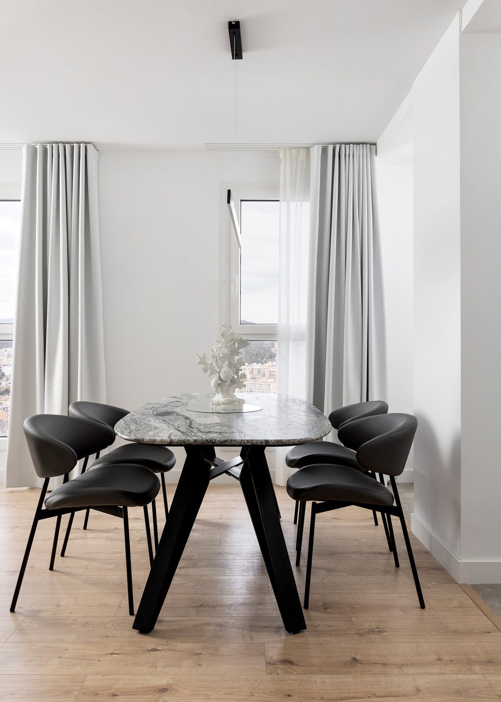 mesa de comedor con sobre de mármol y sillas negras