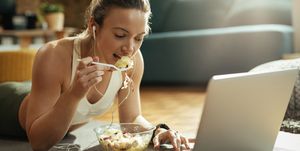 sportieve vrouw eet salade voor laptop