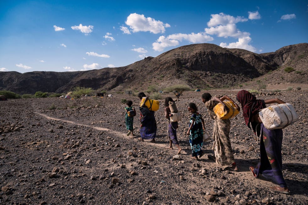 Ethiopische vrouwen keren terug nadat ze bij een naburige put water hebben gehaald Vanwege de aanhoudende droogte moeten vrouwen doorgaans uren en soms dagen lopen om het water te vinden dat ze nodig hebben om van te drinken en mee te koken en te wassen De vrouwen op deze foto uit mei 2021 hadden het geluk dat ze water konden halen uit een naburige put die door een hulporganisatie in de regio is geslagen