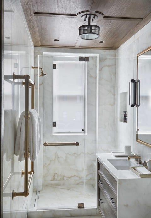 a small marble shower and sink with a dark wood ceiling