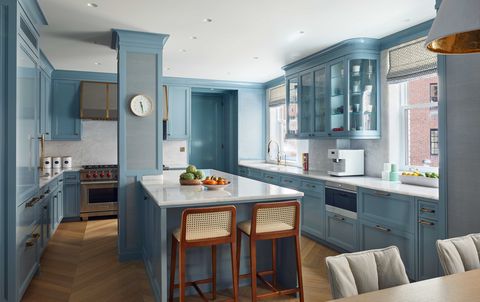 a large light filled kitchen with cabinets covered in a pale blue lacquer