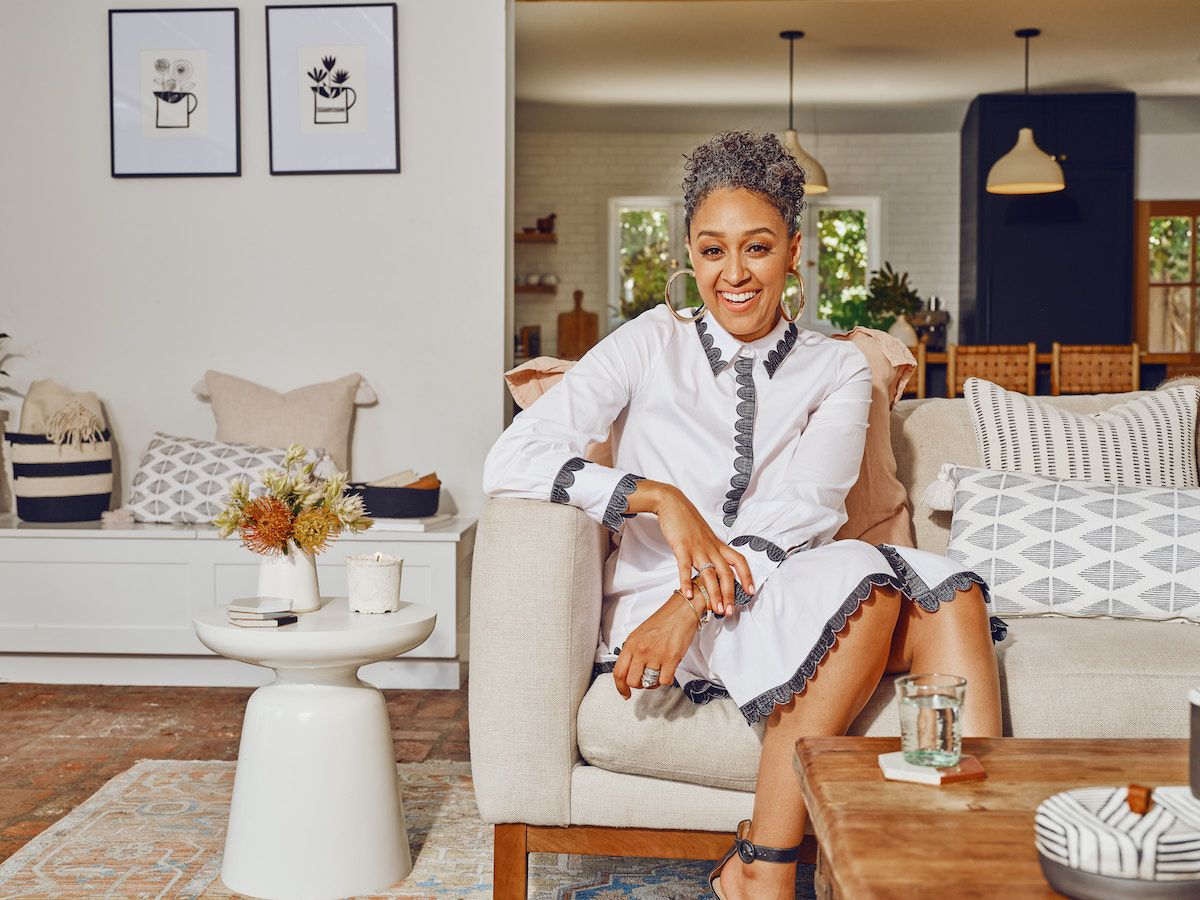 tia mowry sitting on a sofa in a room decorated with her etsy home decor collection