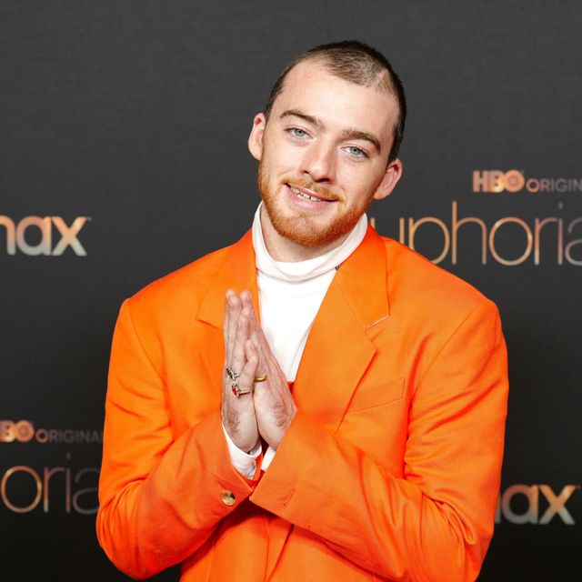 euphoria star angus cloud who has sadly just passed away poses in an orange suit and smiles at the camera