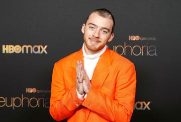euphoria star angus cloud who has sadly just passed away poses in an orange suit and smiles at the camera