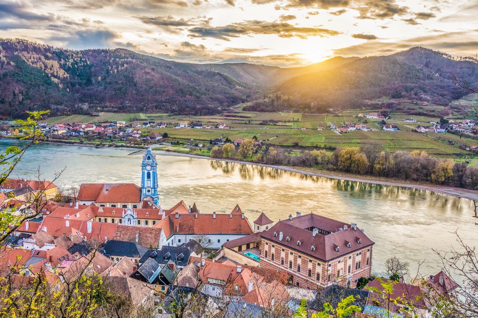 panoramic aerial view of beautiful wachau valley with the historic town of durnstein and famous danube river in beautiful golden evening light at sunset, lower austria region, austria