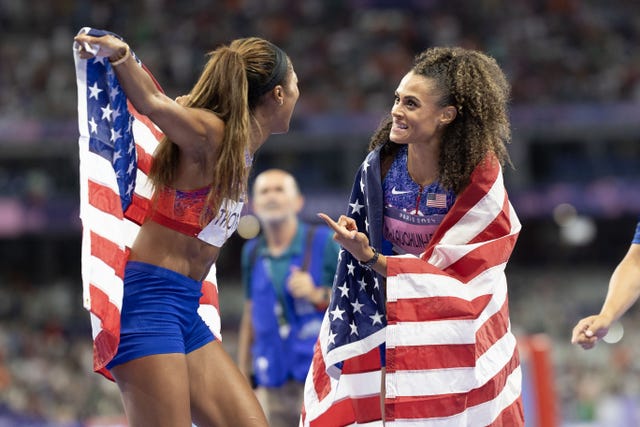 athletes celebrating together with american flags draped around them
