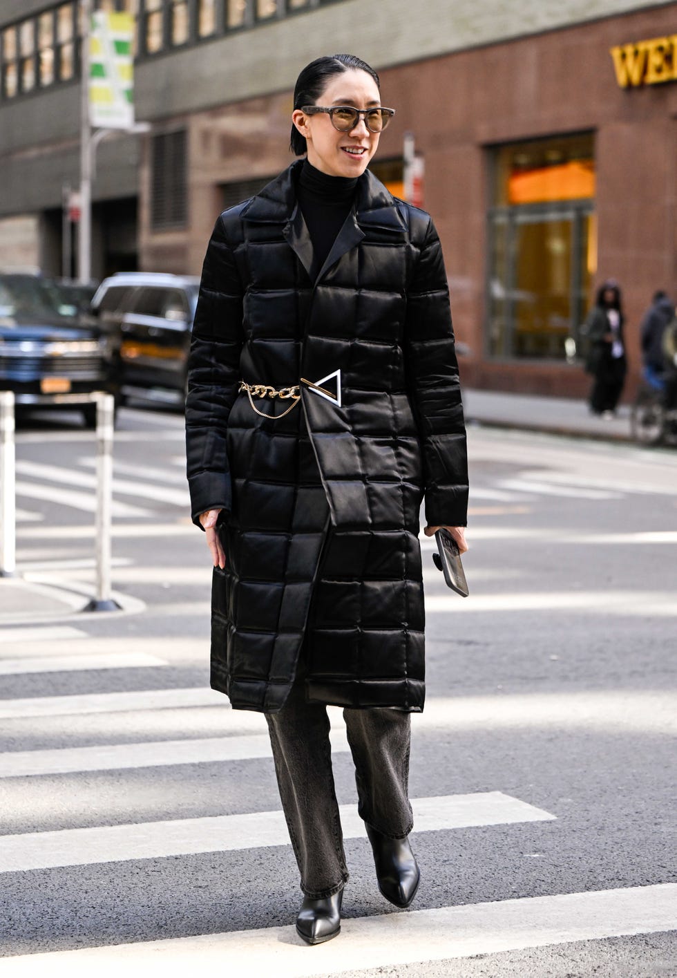 A person walking on a city street in fashionable attire