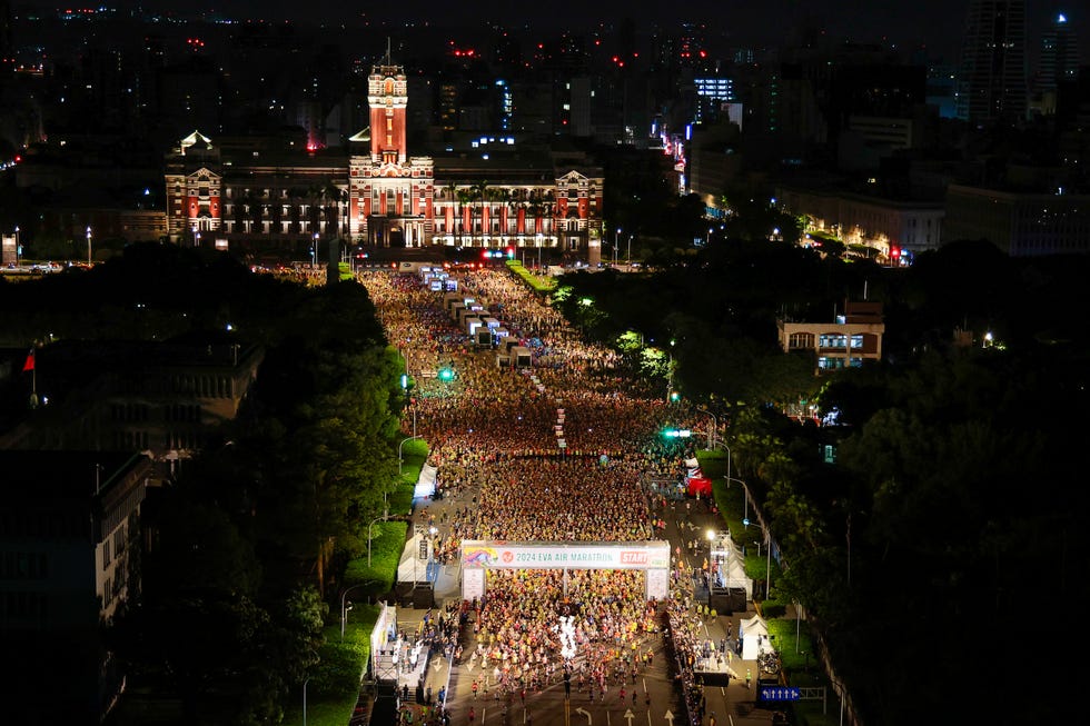 massive crowd gathered at night for a marathon event near a historic building