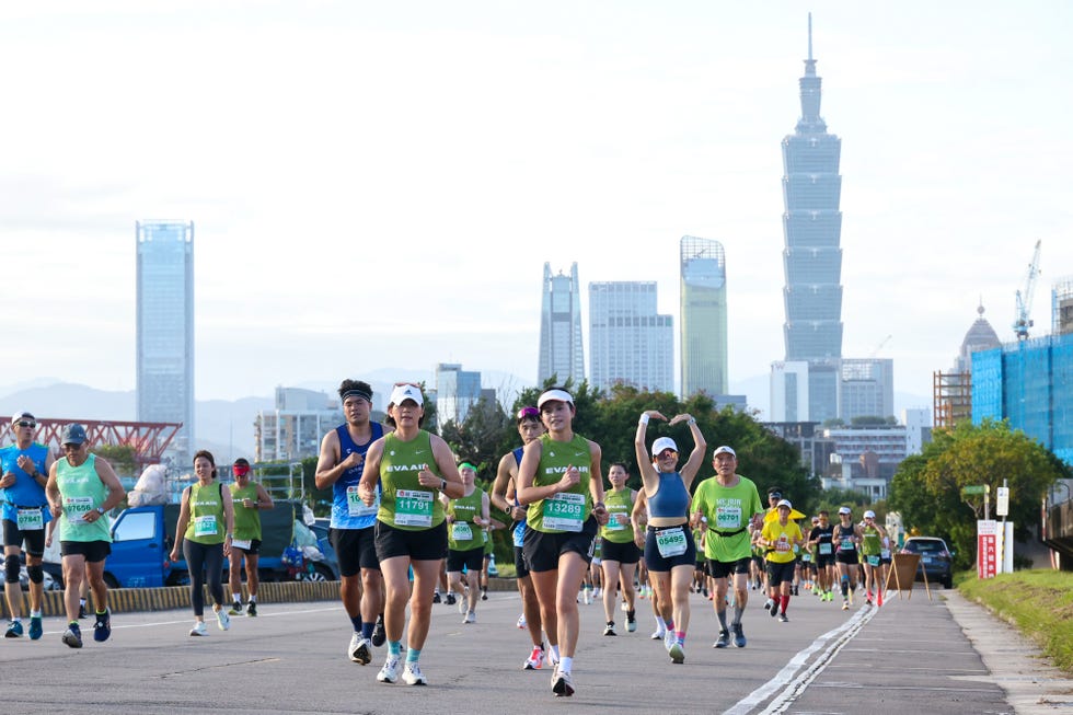 participants running in a marathon with urban skyline in the background