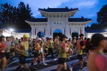 participants running in a race past a traditional archway