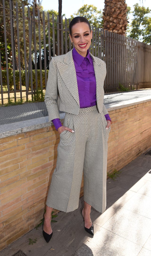 la presentadora con un traje pantalon y blusa morada