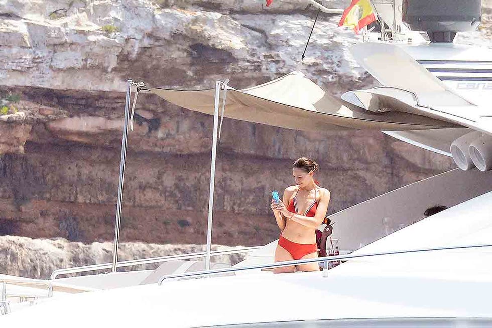 Eva González con biquini rojo móvil en mano en cubierta barco 
