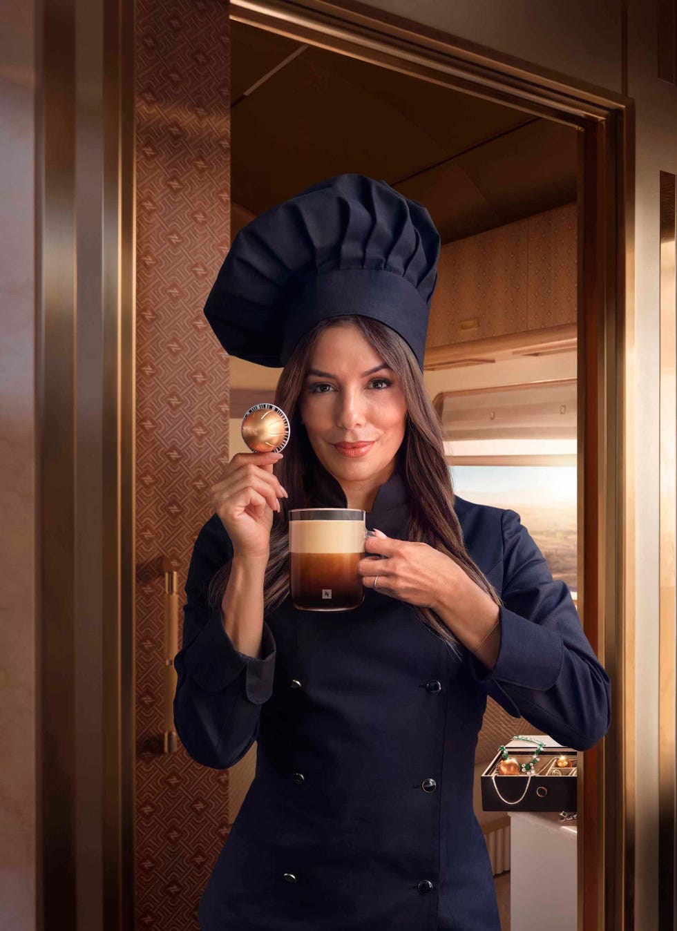 a chef holding a coffee mug and a coffee capsule in a luxurious setting