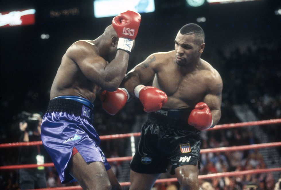mike tyson following through on a punch during a boxing match against evander holyfield