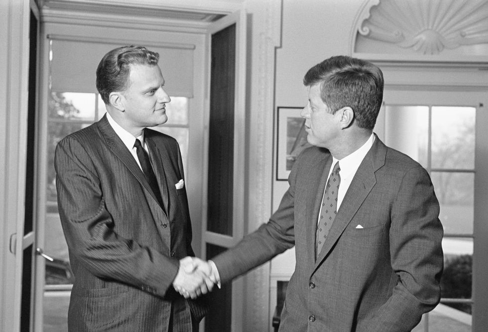 Billy Graham shakes hands with President John F. Kennedy during an unannounced visit to the White House in December 1961