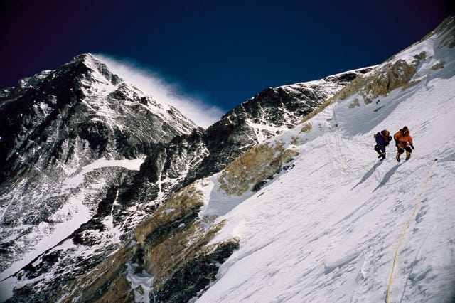 een paar reizigers beklimmen de mount everest